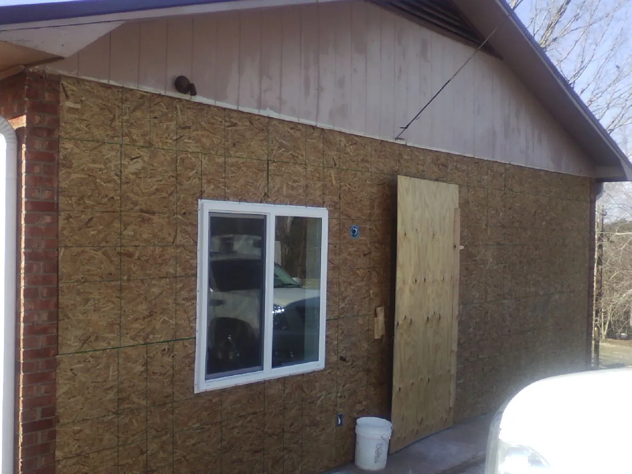 OSB sheathing on a garage addition wall before siding in Merrill