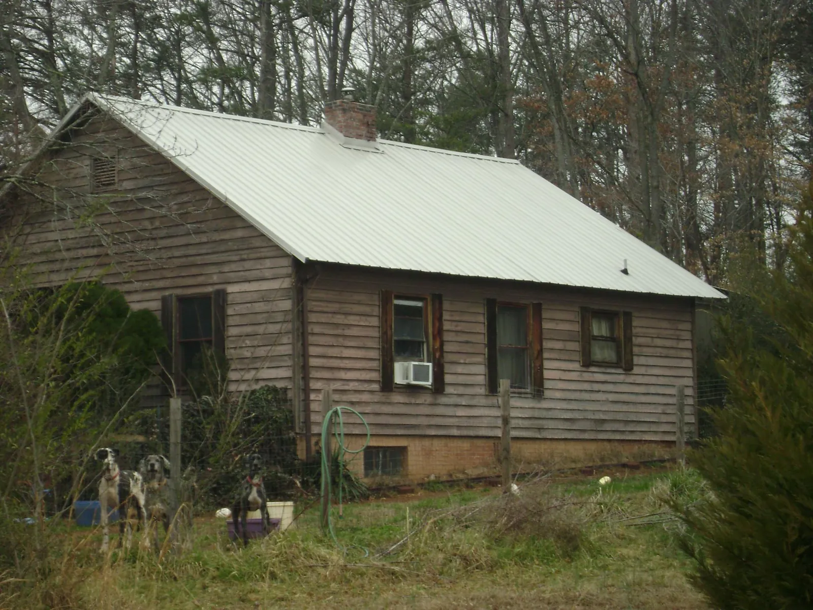 White metal roof on an old wood sided farmhouse, from a Metal Roof Installation job in Merrill